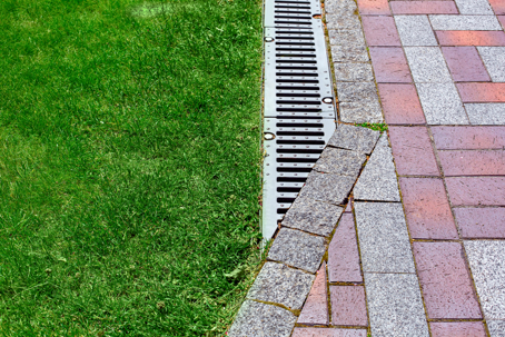 drainage grate bolted to storm drain at corner